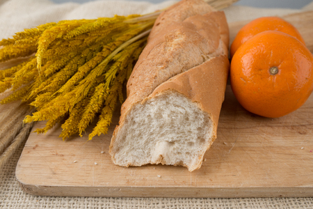French bread baguettes on bread board and mandarin orangesの写真素材