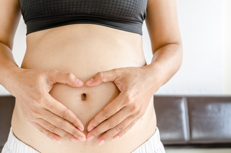 Close up pregnant women touching her belly with handsの写真素材