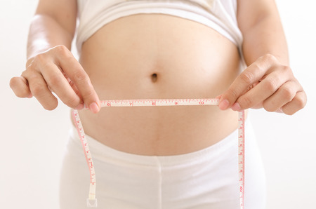 Pregnant women measure her bellyの写真素材