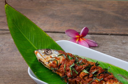 Fried mackerel fish in red curry sauce with slice kaffir lime leavesの写真素材
