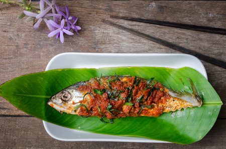 Fried mackerel fish in red curry sauce with slice kaffir lime leavesの写真素材