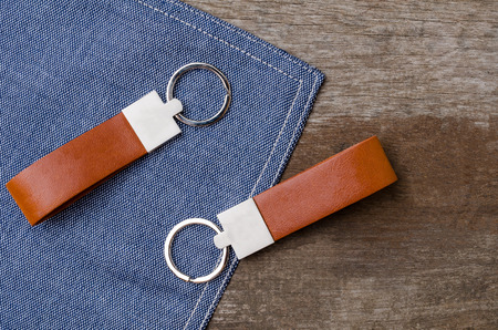 Leather key chain with blue fabric on wooden backgroundの写真素材