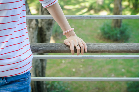 Woman hand with  heart shaped ring of silver on wooden bridgeの写真素材