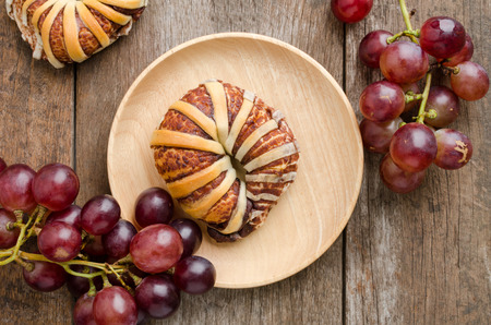 Fresh bread and grapes on old wooden backgroundの写真素材