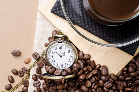 Coffee time concept with vintage pocket watch on coffee beans backgroundの写真素材