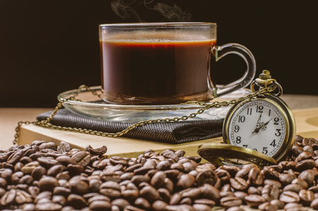 Coffee time concept with vintage pocket watch on coffee beans backgroundの写真素材