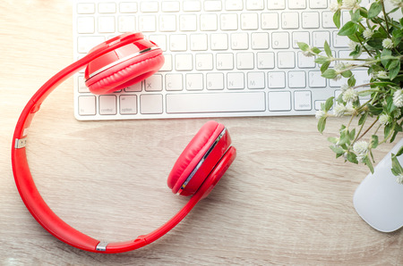 Workspace with headphones, computer keyboard and computer mouse on wooden backgroundの写真素材