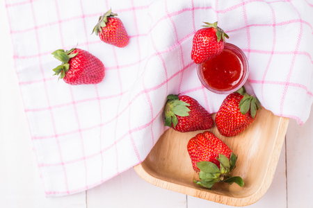 Strawberry jam in glass with fresh strawberry on white wooden backgroundの写真素材