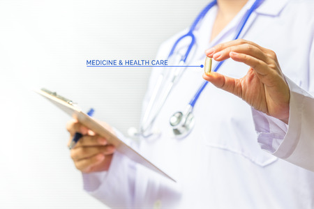 Close up of doctor hands holding medicine pill on white background.  Medical and healthcare conceptの写真素材