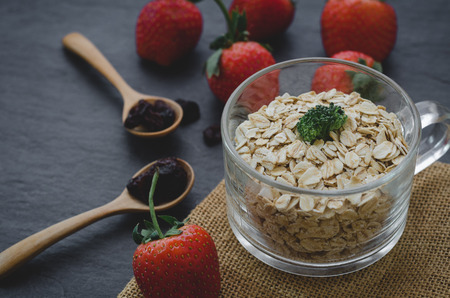 Fresh breakfast of healthy oatmeal in glass with strawberries on wooden backgroundの写真素材