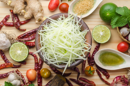 Ingredients for making papaya salad on a wooden table. Set of Thai spices and herbsの写真素材