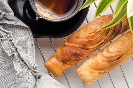 Sweet breakfast with curry puff pastry and tea on white wooden background.