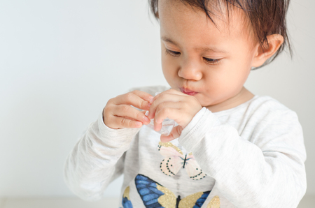 Asian little girl takes medicine syrup by herselfの写真素材