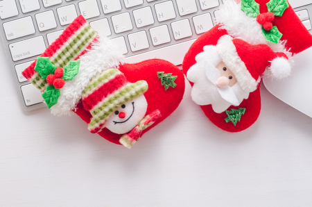 Wooden working table with computer keyboard, mouse and  christmas socks. View from above with copy space.の写真素材