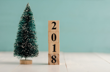 Wooden cube with 2018 label for new year decoration on pastel background