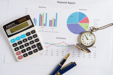 Top view of working table with financial report, pocket watch, calculator and pen. Business Concept.の写真素材