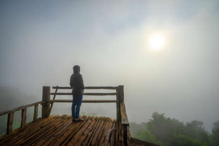 Woman standing in the morning fog miss someone, Ban Ja Bo , Mae Hong Son, Thailandの写真素材