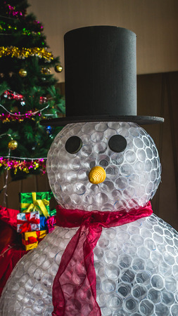 Christmas decoration, Snowman made from plastic glasses in front of Christmas treeの写真素材
