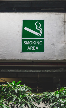 smoking designated area sign mounted on the wall in the open space of public building.の写真素材