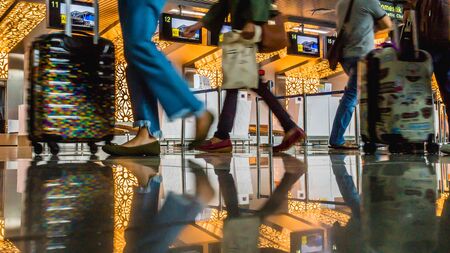 The activity in the airport terminal building, passenger with luggage trolley in front of check-in counter deskのeditorial素材