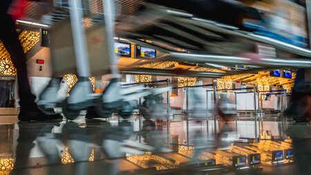 The activity in the airport terminal building, passenger with luggage trolley in front of check-in counter deskのeditorial素材