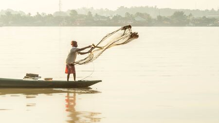 Samarinda / Indonesia - 8/19/2018 : traditional fisherman in Mahakam river catching fish using net in the morningのeditorial素材