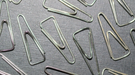 metallic triangular paper clip. office and school supply backgroundの写真素材
