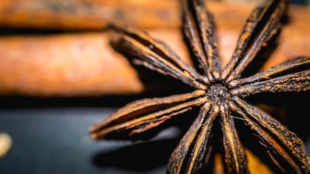 various aromatic spices and herbs on black background. star anise, cloves, cardamom, cinnamon stickの写真素材