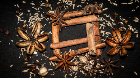 various aromatic spices and herbs on black background. star anise, cloves, cardamom, cinnamon stickの写真素材