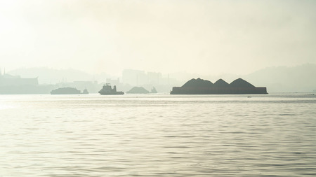 tugboat with barge of coal on Mahakam river, Samarinda, Indonesiaの写真素材