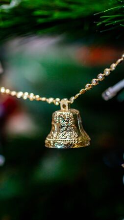 golden bell hanging on Christmas tree. Christmas and New Year backgroundの写真素材