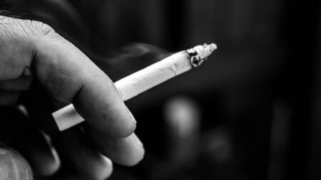 closeup of fingers holding a cigarette