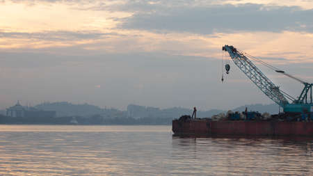 A ship with boat on Mahakam River in the morning.の写真素材