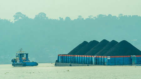 Tugboat dragging barge full of coal, Mahakam River. Taken from behindの写真素材