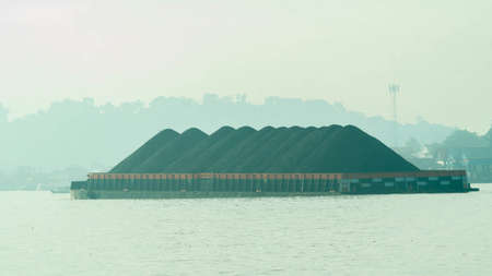 Tugboat dragging barge full of coal, Mahakam River. Taken from behindの写真素材