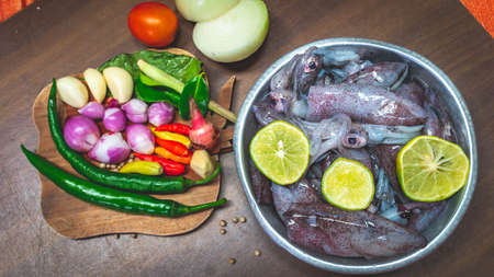 cuttlefish and spices on the cuttingboard. Preparation before cooking calamariの写真素材