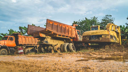 Wreck of heavy machinery in the junkyard of forestry company. Broken old rusty truck and excavatorの写真素材