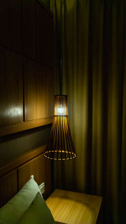 Artistic lamp hood made from wood in the corner of bedroomの写真素材