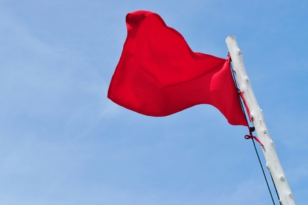 Red flag and blue skyの写真素材