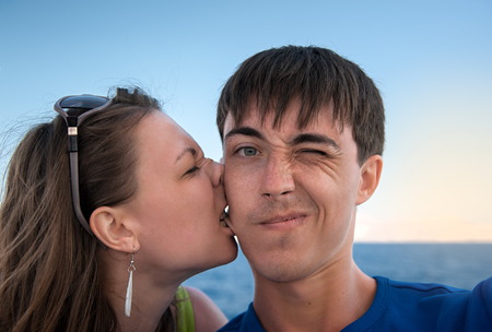 cheerful young couple on a background of blue skyの写真素材