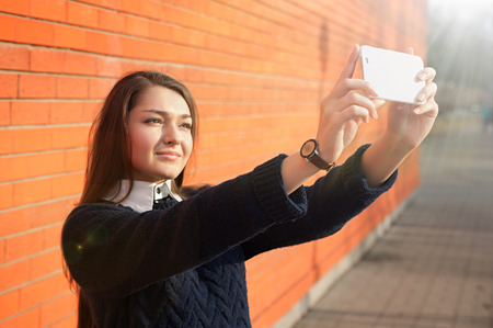 Young woman taking selfie with smartphone cameraの写真素材