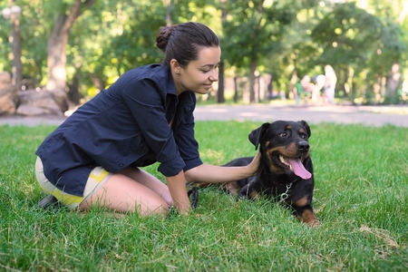 Beautiful woman and rottweiler in a parkの写真素材