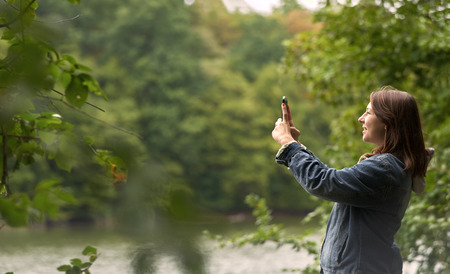 woman taking pictures on the river bank