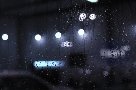 Rain drops on window with street bokeh lights