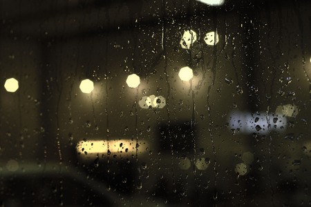 Rain drops on window with street bokeh lightsの写真素材