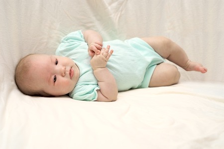 Happy baby lying on bedの写真素材