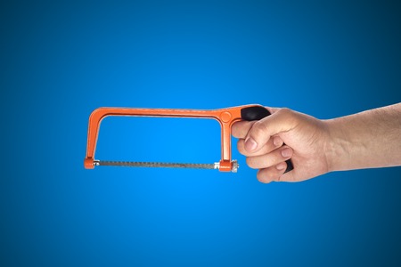 hand holding a sawの写真素材