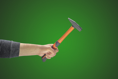 man's hand holding a hammer on a plain backgroundの写真素材