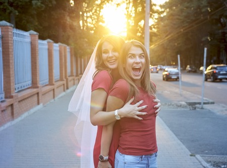 Two friends hugging outsideの写真素材