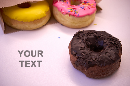 Delicious donuts fall out of the package on a wooden backgroundの写真素材